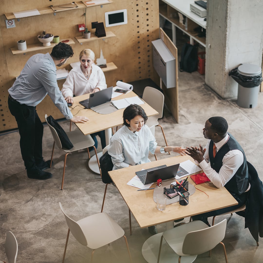 diverse-team-collaborating-aerial-view-industrial-office-workspace-Hero