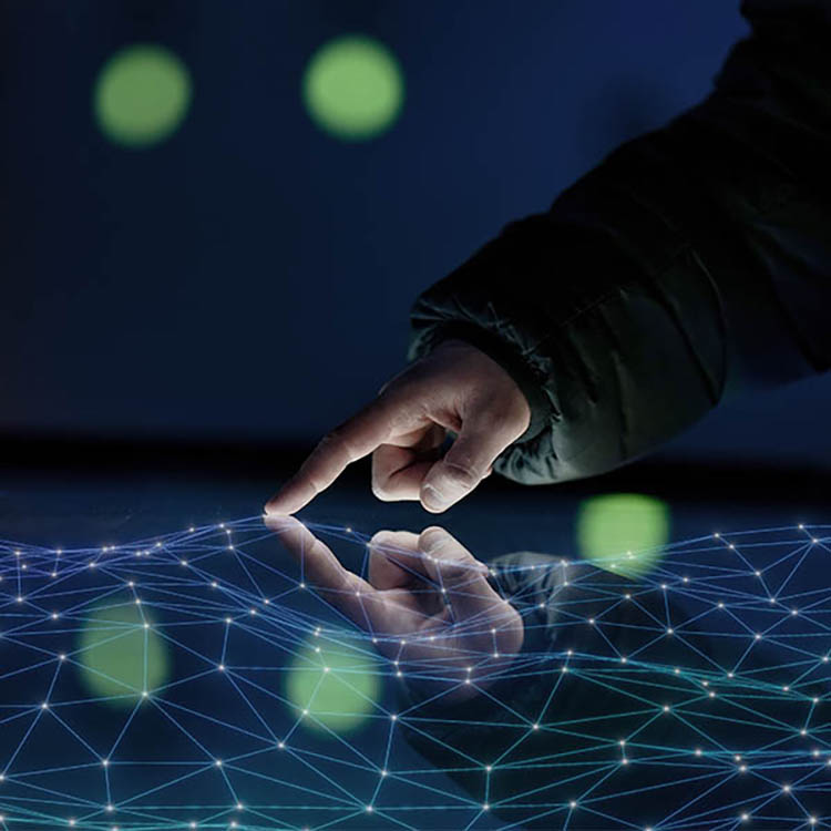Close-up of a hand interacting with a glowing digital network interface on a touchscreen