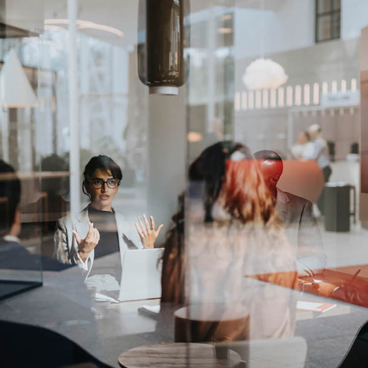 Business team having a collaborative meeting around a table in a modern office with glass walls