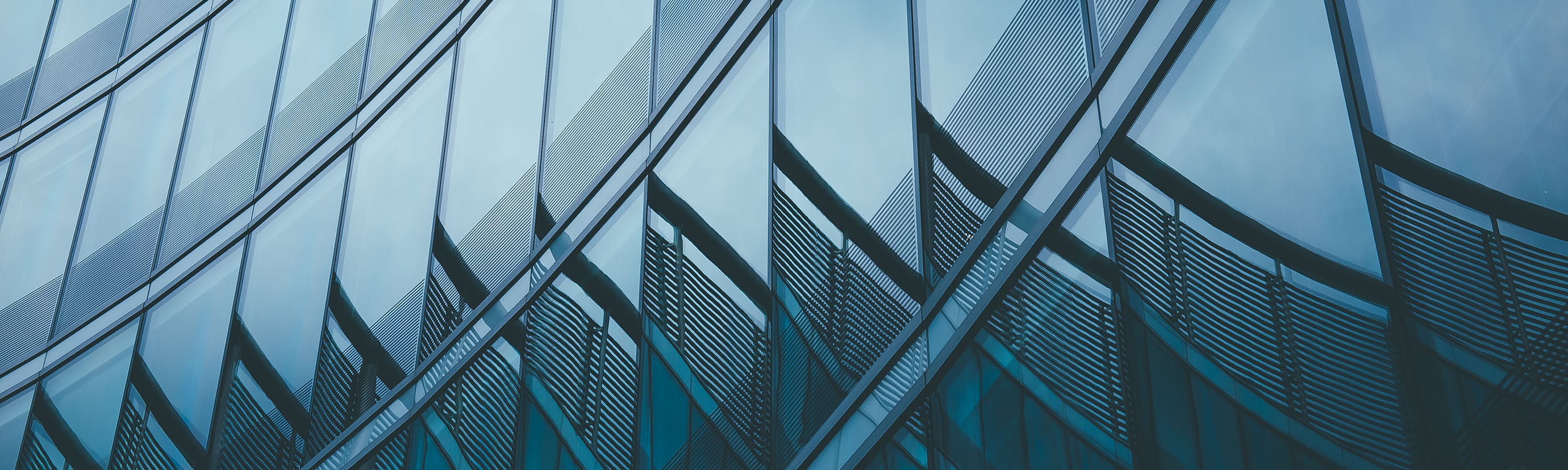 Close-up of a modern commercial building's curved glass curtain wall facade