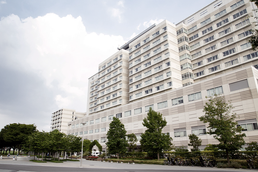 Modern multi-story hospital building with trees in front.