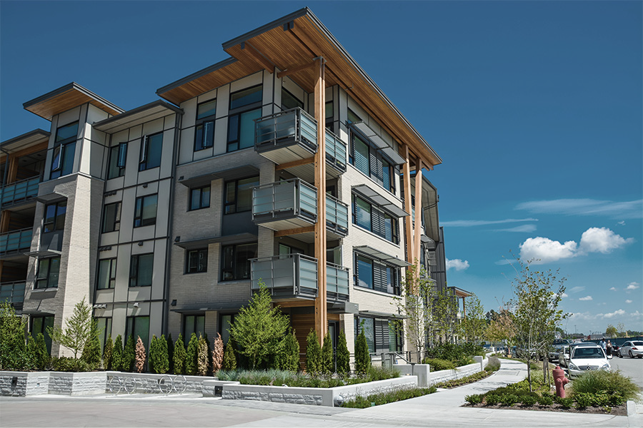 Contemporary apartment building with balconies and landscaping.