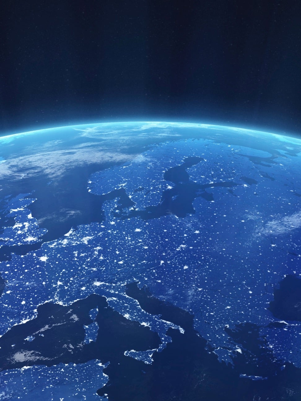 View of Earth from space showing illuminated cities at night across Europe and surrounding regions