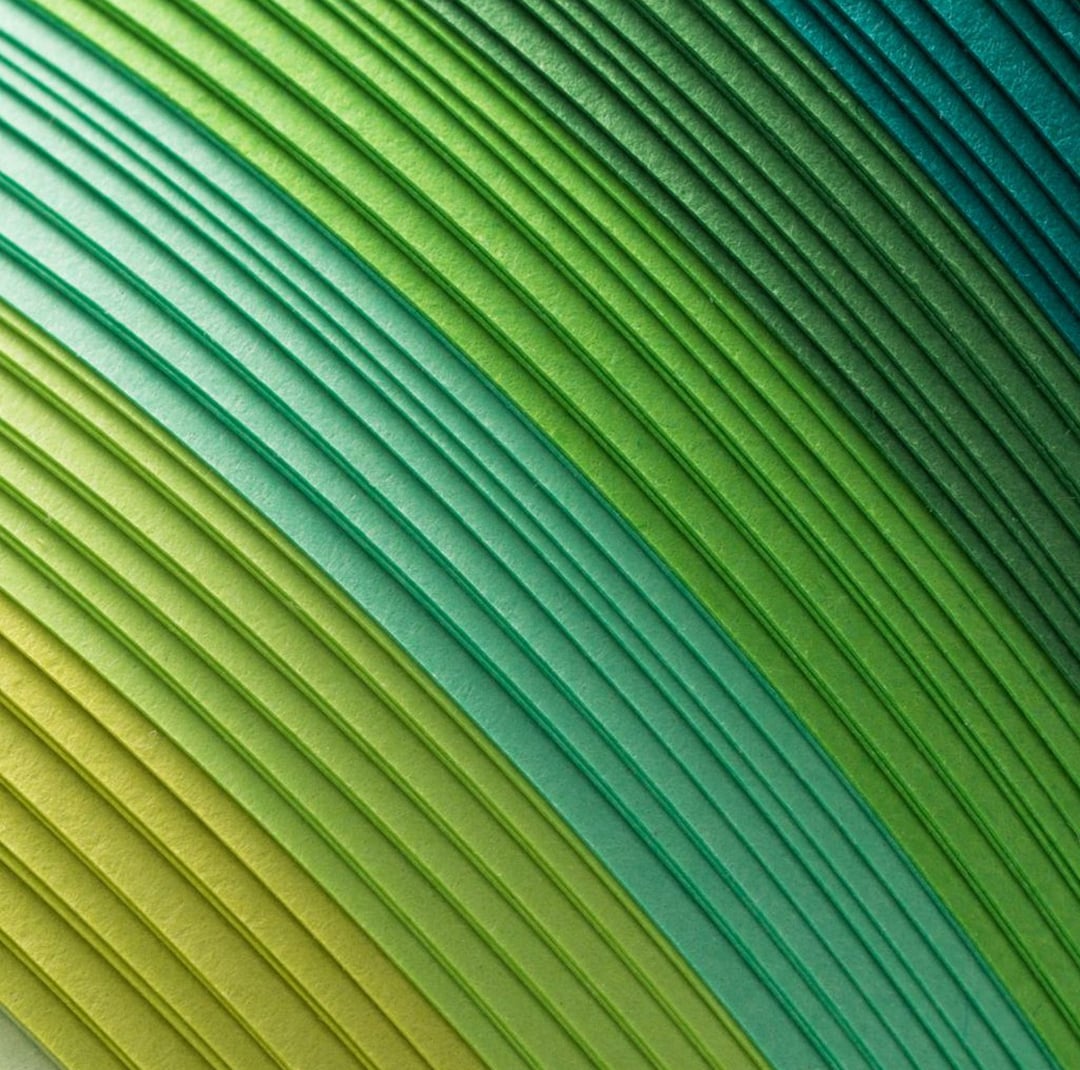 Close-up abstract texture of layered diagonal ridges transitioning from yellow-green to teal in a sweeping gradient pattern