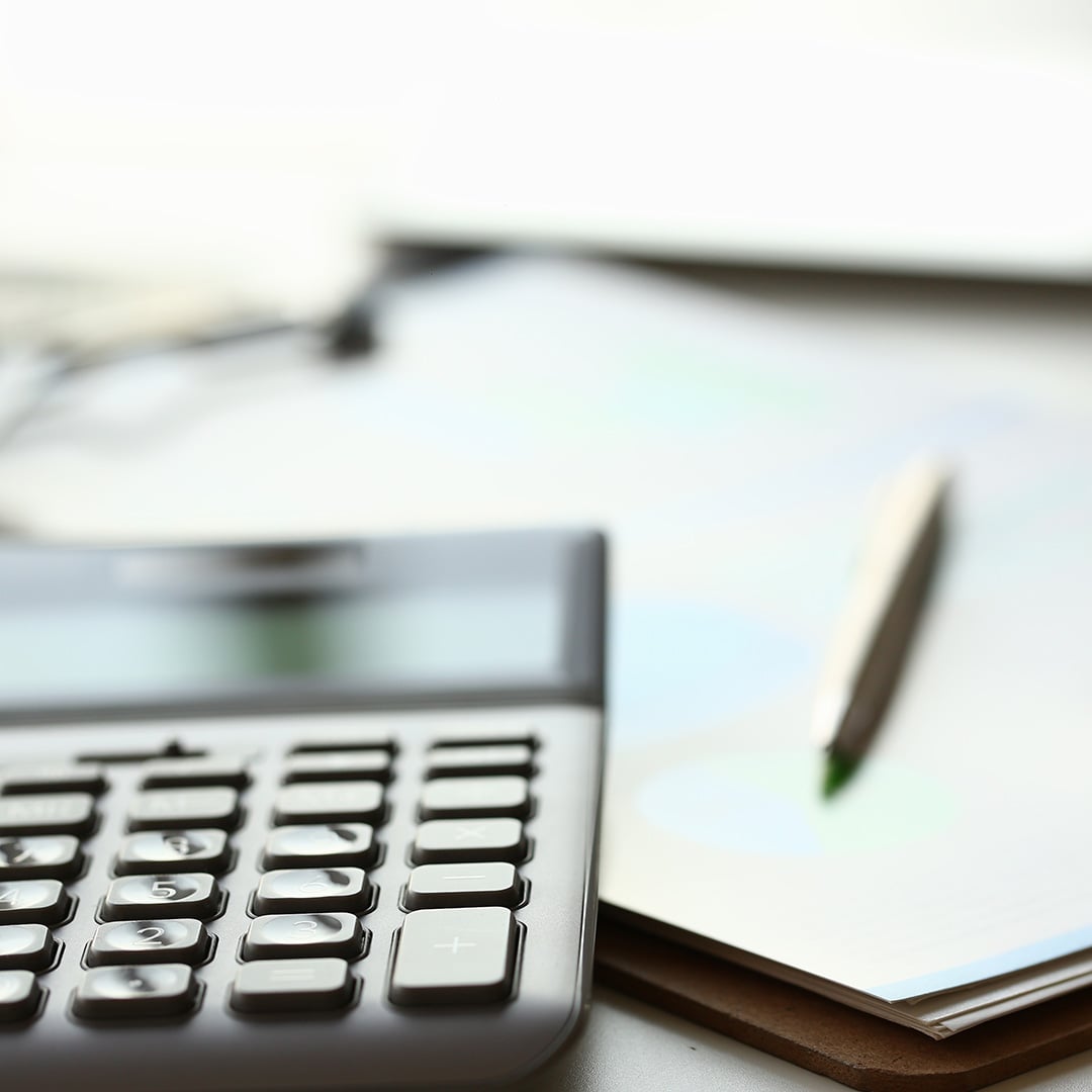 A calculator and pen on a notepad
