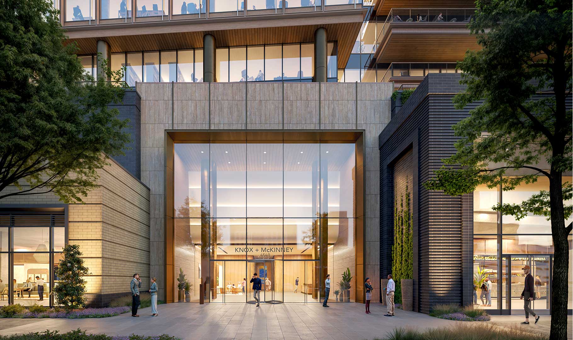 Street‑level entrance of Knox & McKinney office building with glass facade, modern architecture, landscaped plaza, and people entering a luxury mixed‑use property.