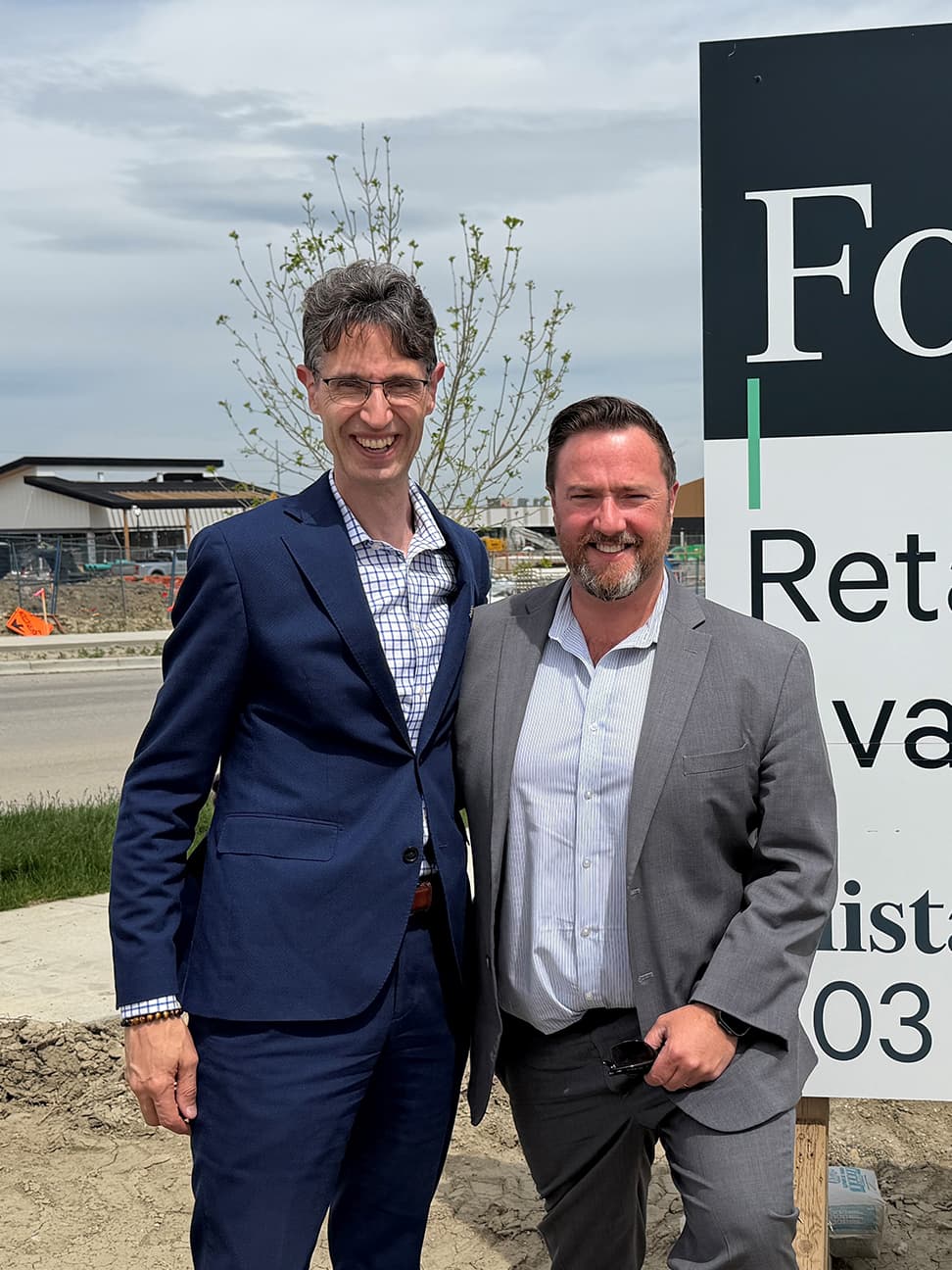Alistair Corbett and Cory Miles standing in front of a grocery anchored plaza construction site