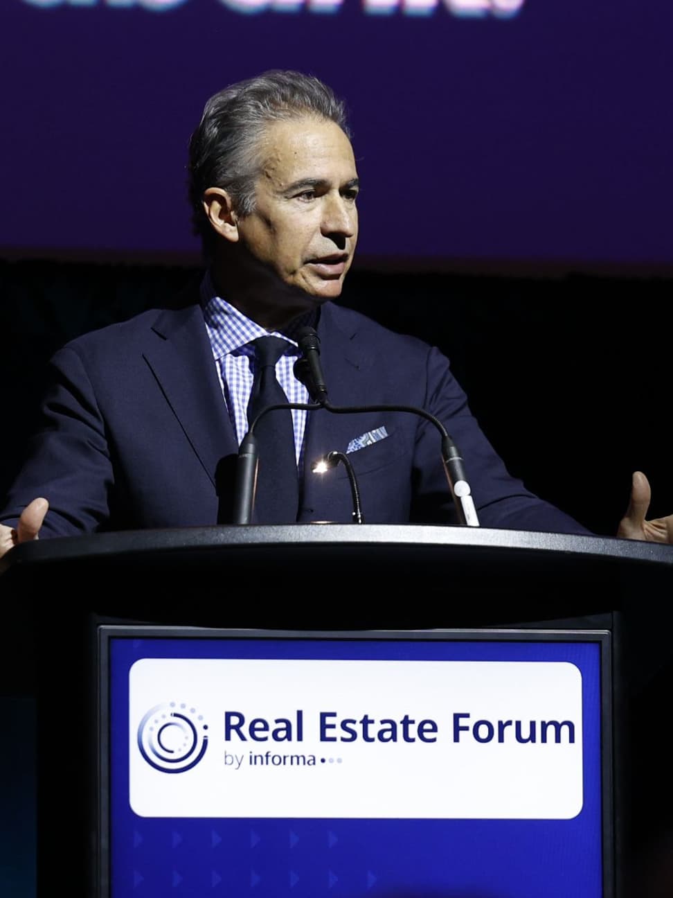 Paul Morassutti speaking at podium at the 2025 Real Estate Forum