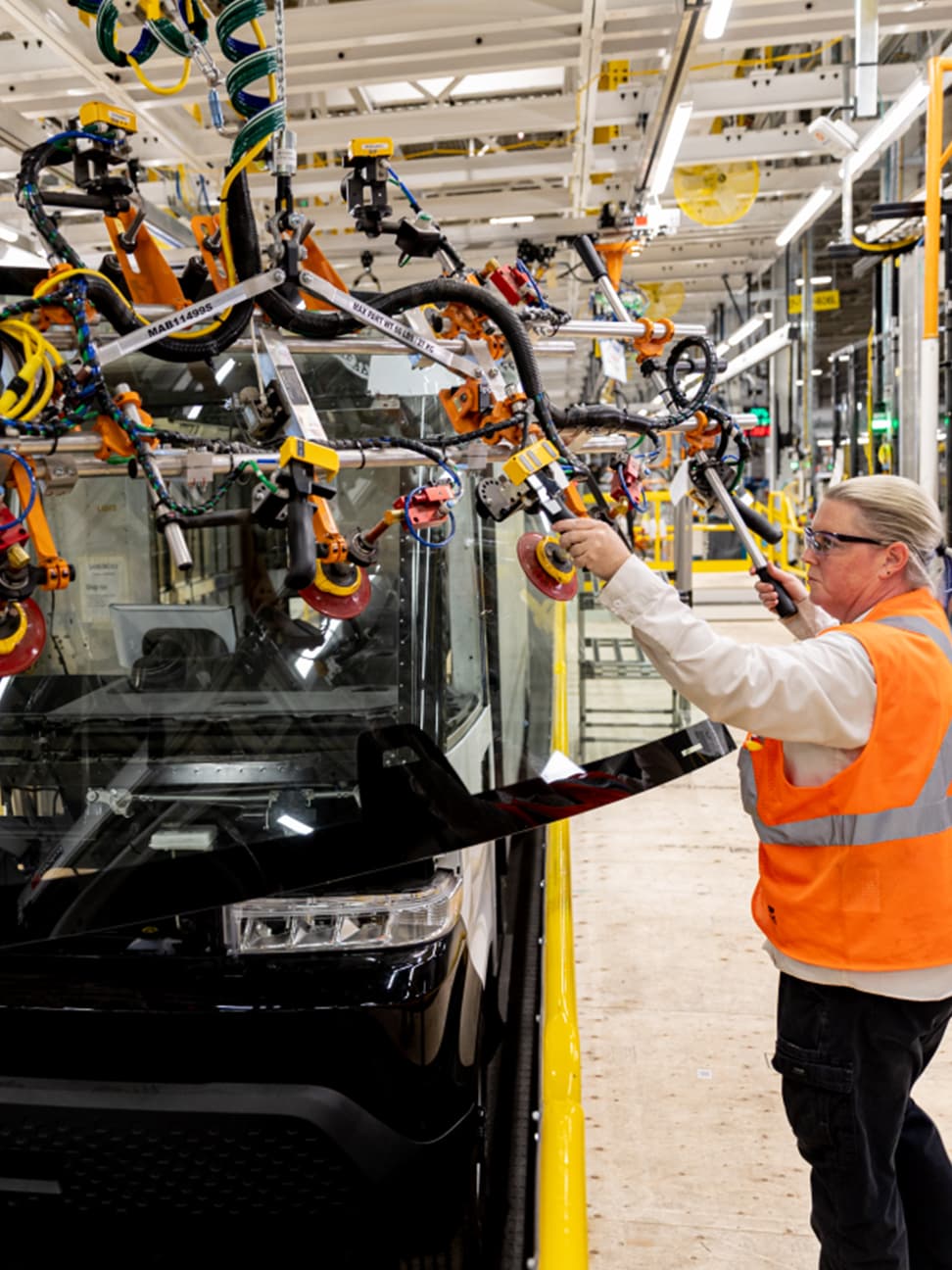 Woman working at automotive plant on assembly line.