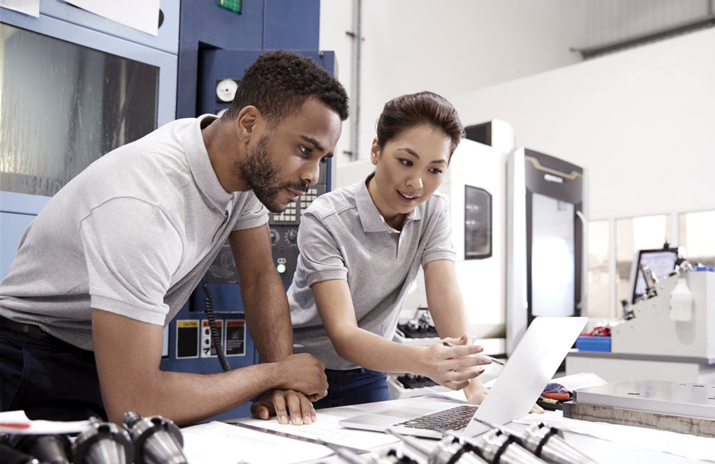 A man and a woman working on laptop in a lab