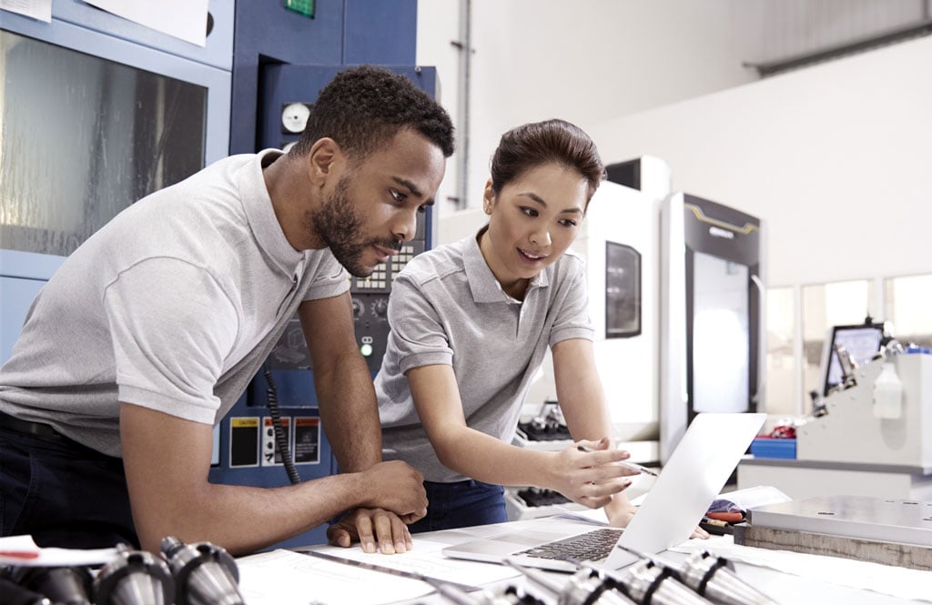 A man and a woman working on laptop in a lab