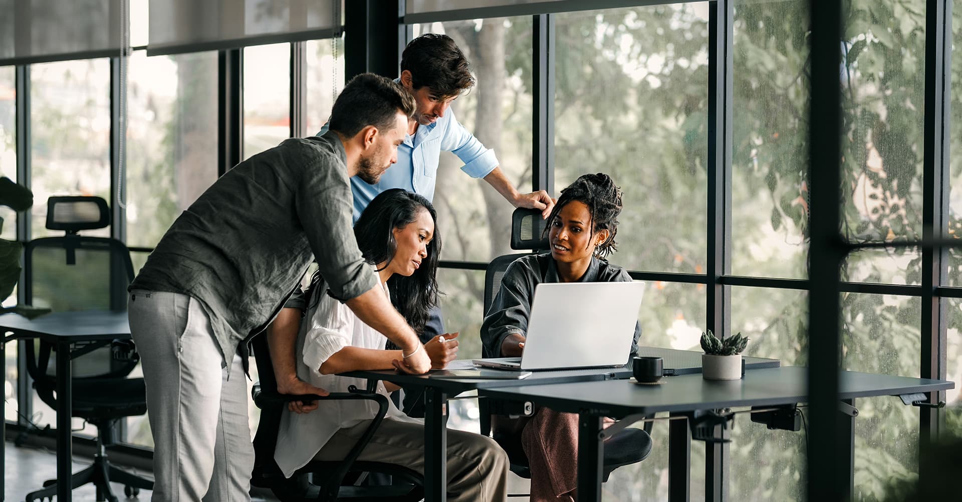 Group meeting around office desk with computer