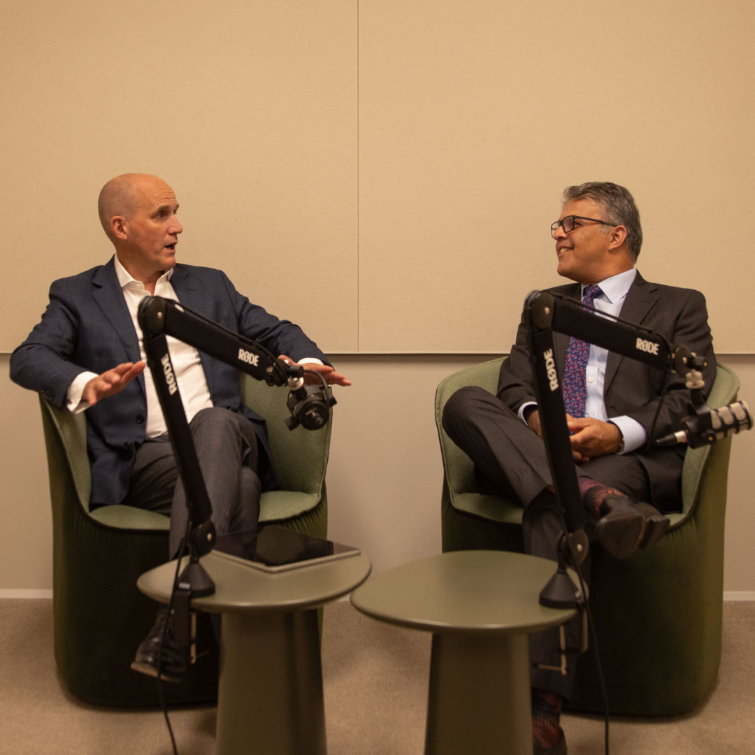 Phil Rowland, on the left, and Sameer Chopra, on the right, are seated in comfortable chairs with microphones in front of them, engaged in a discussion during the filming of "The House View Q4 2025".