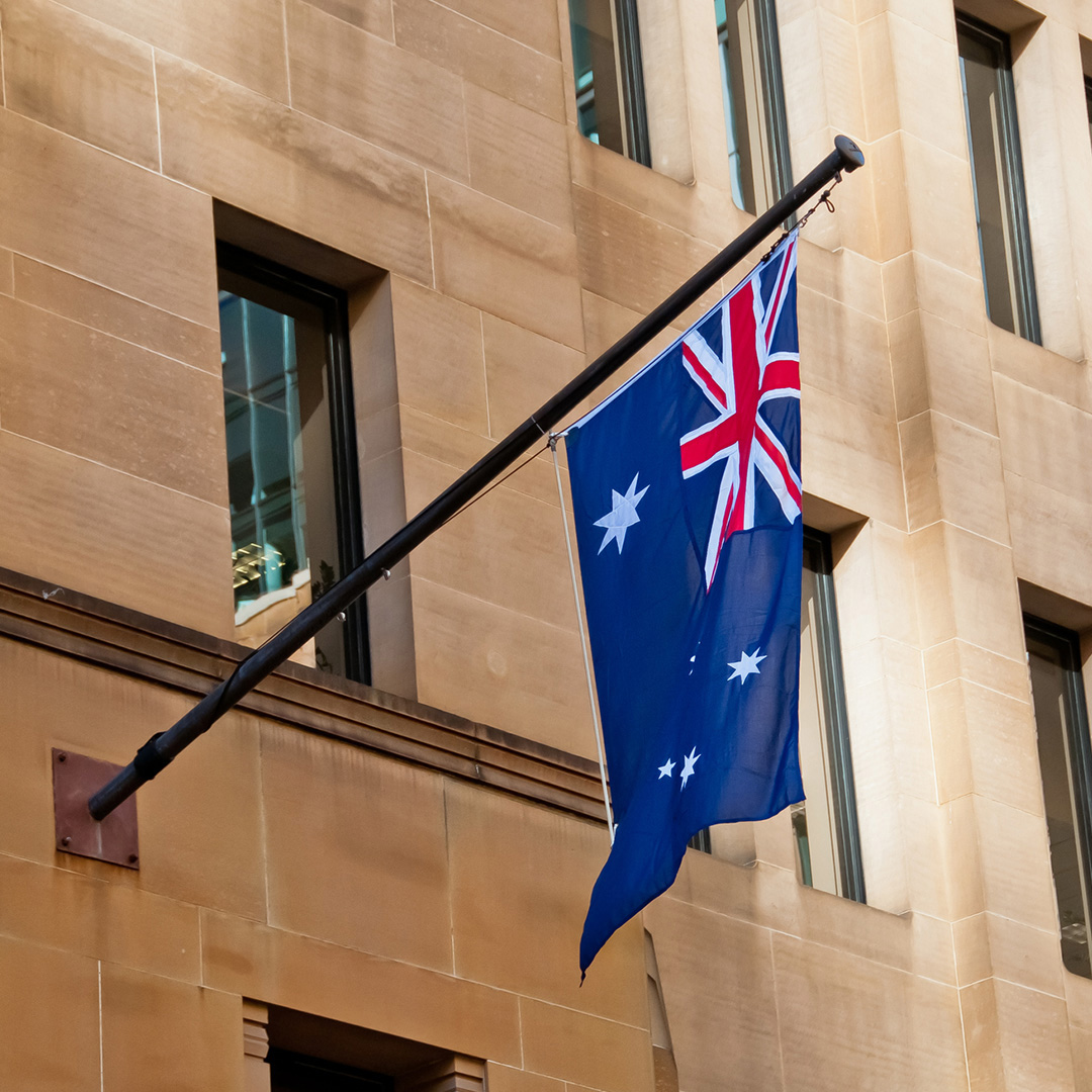 The Australian flag hangs from a building's exterior wall.