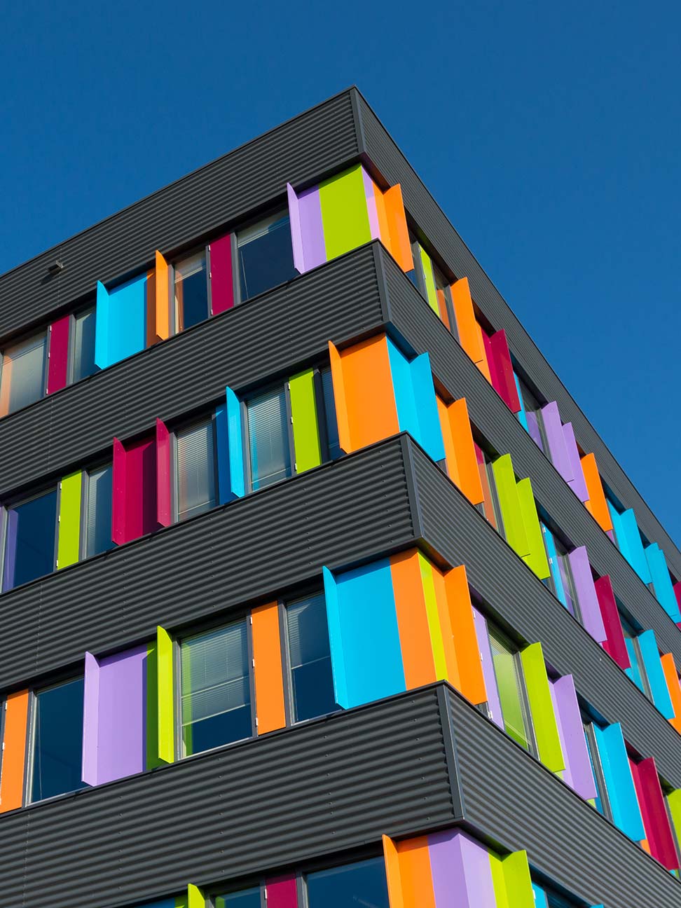Kantoorlocatie in Zwolle met kleurrijke gevelpanelen, grote raampartijen en opvallende architectuur. Representatief kantoorgebouw voor bedrijven.