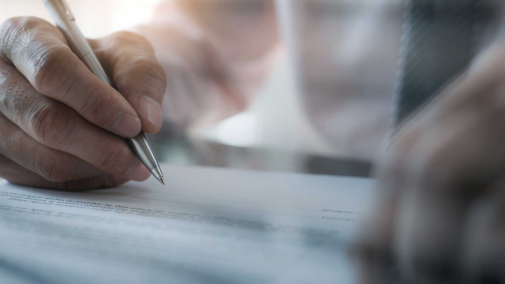Hand die met pen een zakelijk document ondertekent op bureau, symbool voor contracten, vastgoed financiering en alternatieve financieringsoplossingen.