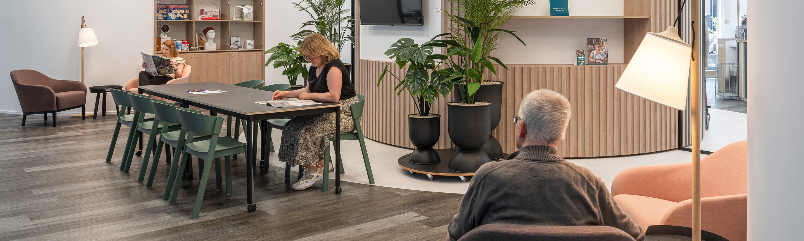 Modern en licht zorgvastgoedinterieur met zitplekken, een ontmoetingsruimte en geïntegreerde zorgvoorzieningen.