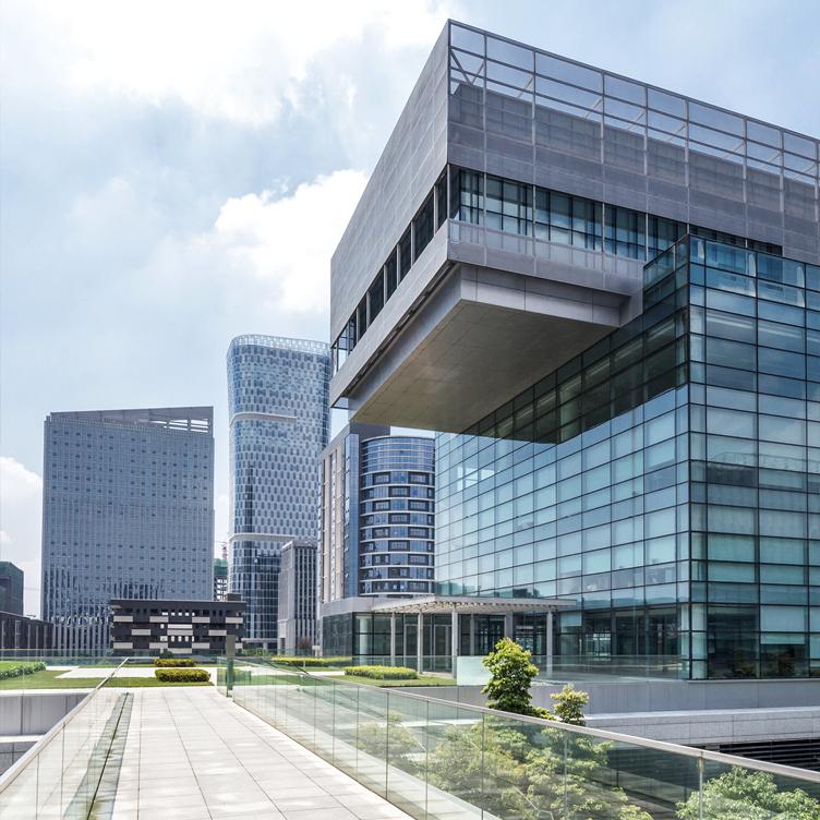 Glass office building with clean facade, large floor plates and roof terrace, set in an urban area with high rise buildings and greenery for commercial real estate.