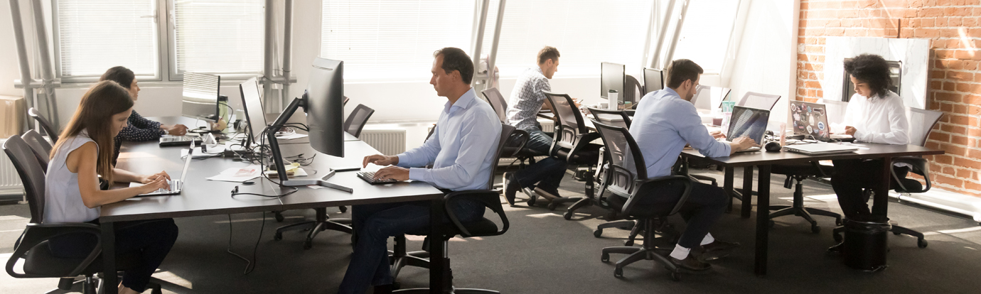 Diverse workers sitting at desk working in coworking space