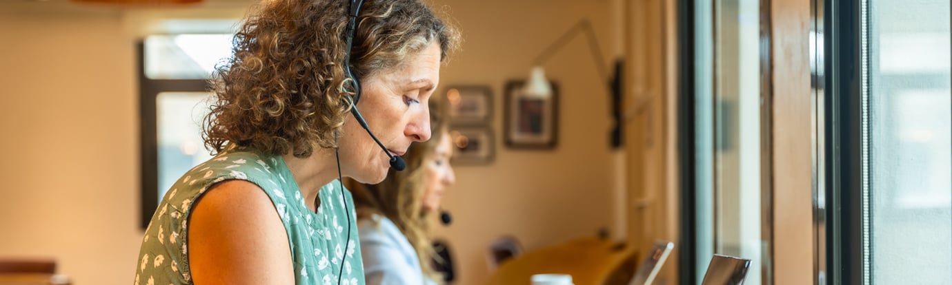 Women working in coworking space wearing headsets