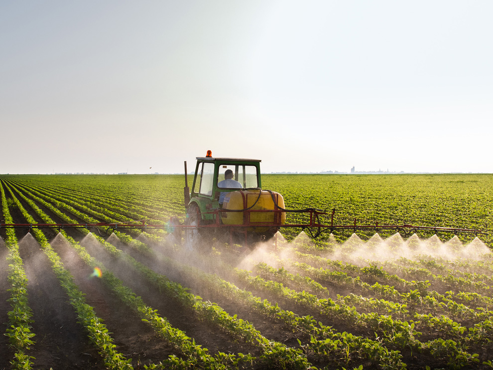 Tractor spraying soybean field