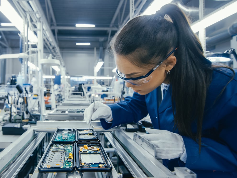 Shot of an electronics factory workers assembling circuit boards by hand while it stands on the assembly line