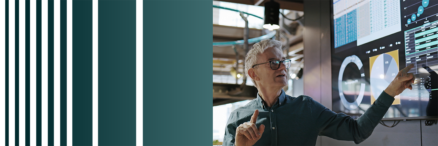 A person in a conference room pointing to a screen