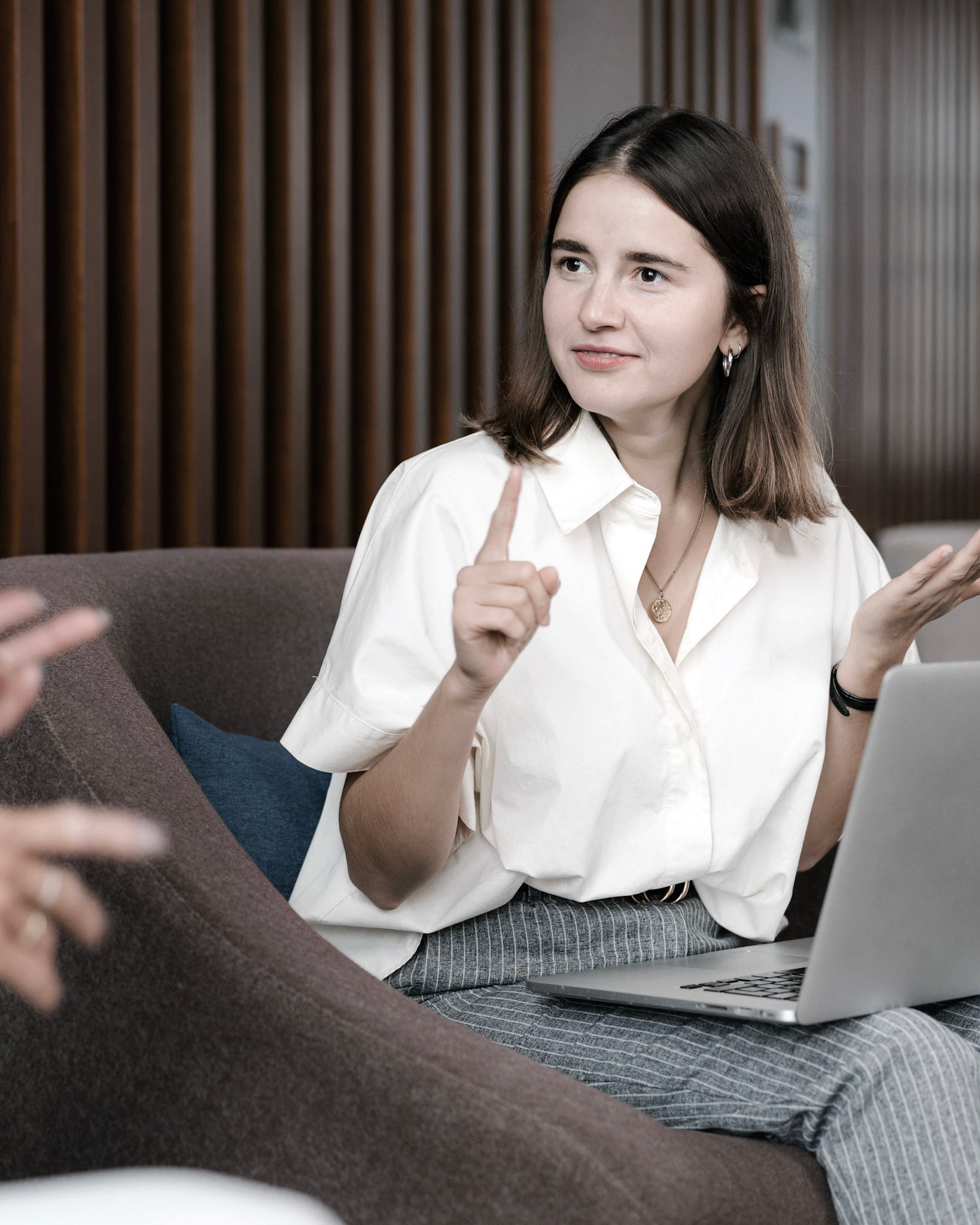 A person sitting on a couch with a laptop