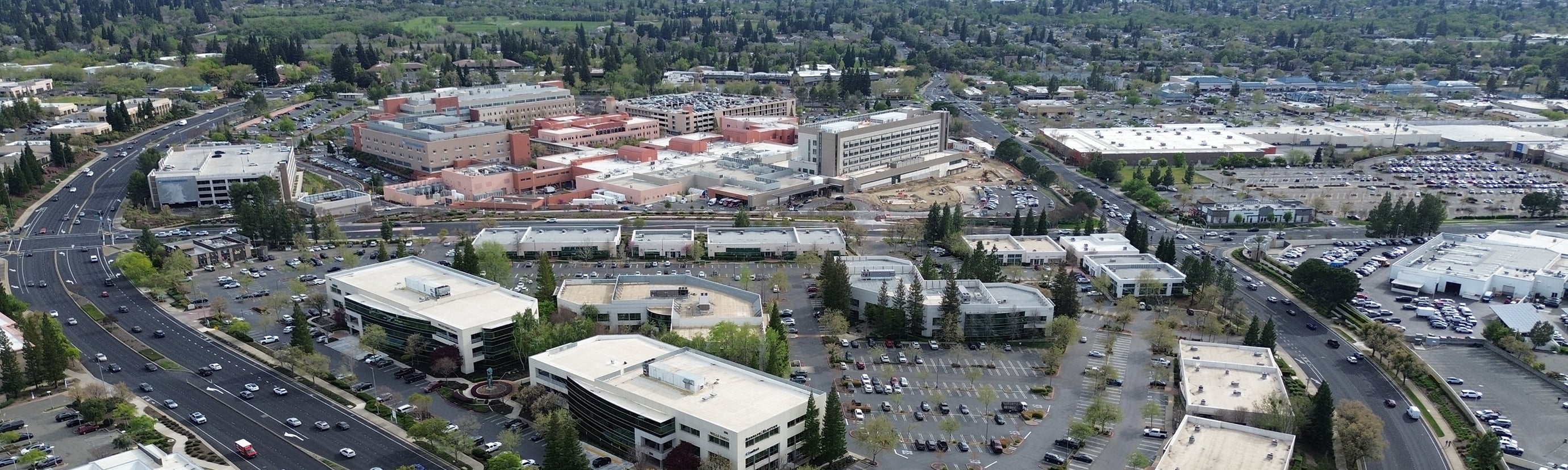 Aerial view of an office park with multiple low-rise buildings, parking lots, and surrounding roadways in Roseville, California