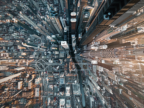 Aerial view of dense city skyscrapers from above, creating dramatic perspective