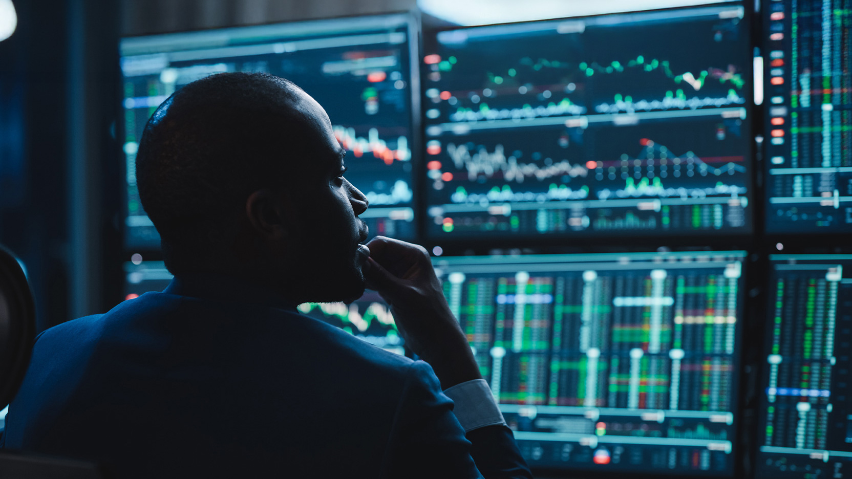 Person reviewing data on various monitors.