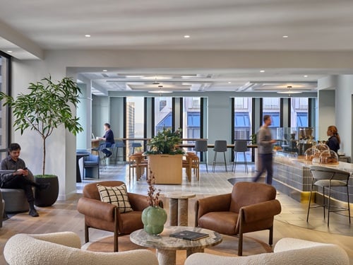 Upscale corporate amenity lounge with leather seating, café bar, and floor-to-ceiling windows