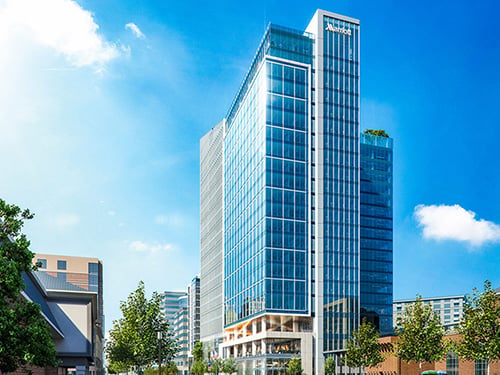 Exterior of Marriott International headquarters office tower featuring a modern glass curtainwall high-rise with Marriott signage and rooftop terrace.