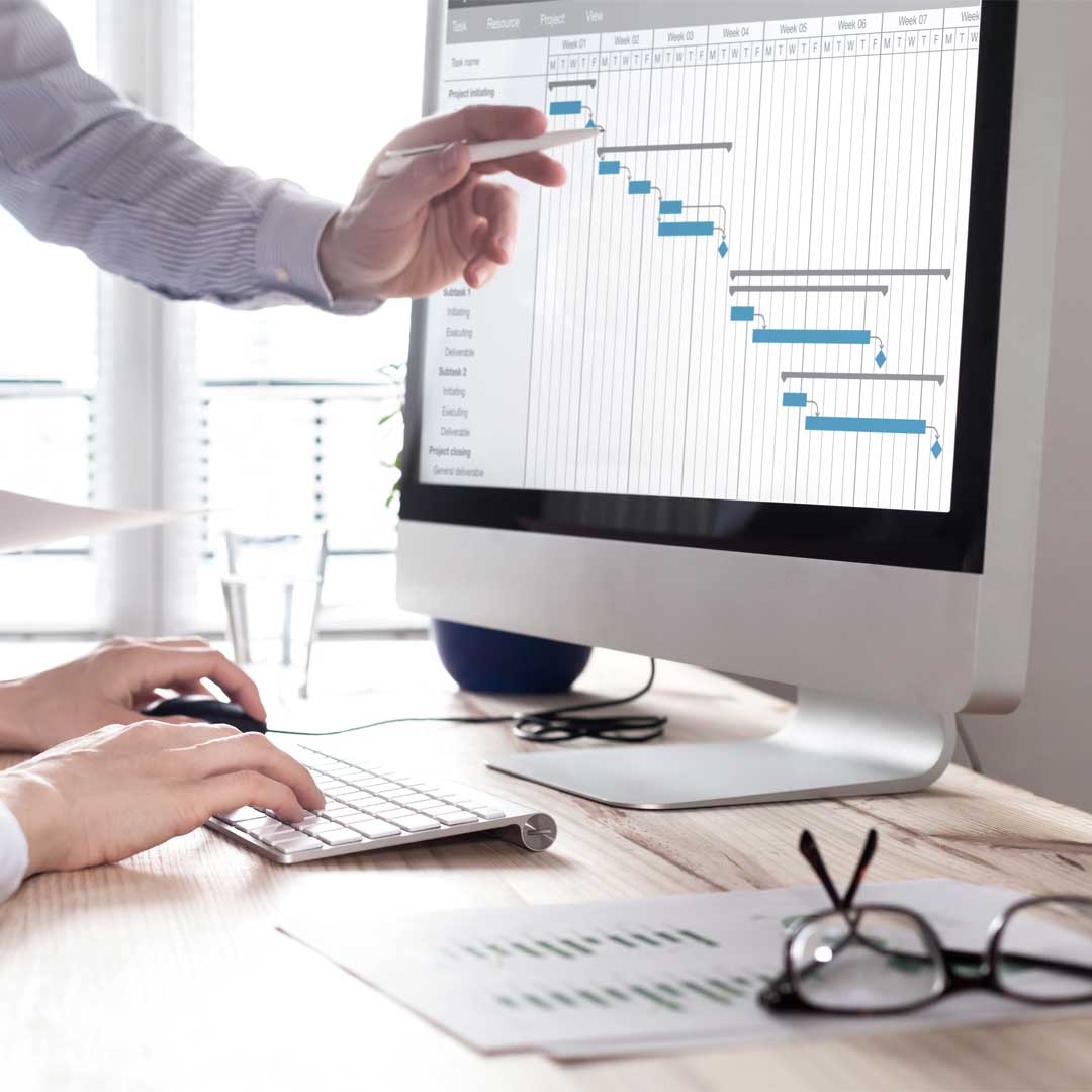 Project management team updating schedule or planning on computer, business