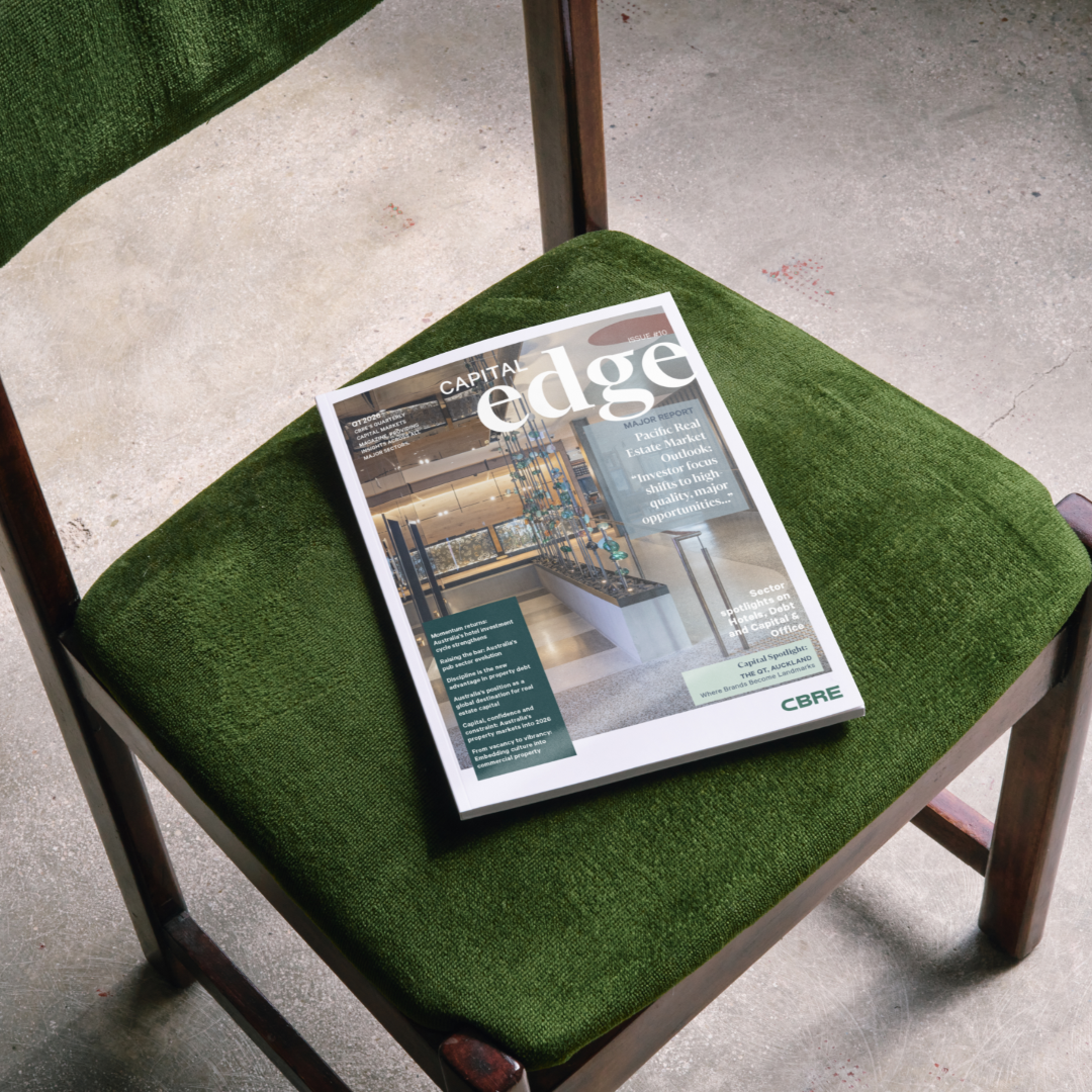 Issue 10 of Capital Edge magazine lies on a dark green upholstered chair.