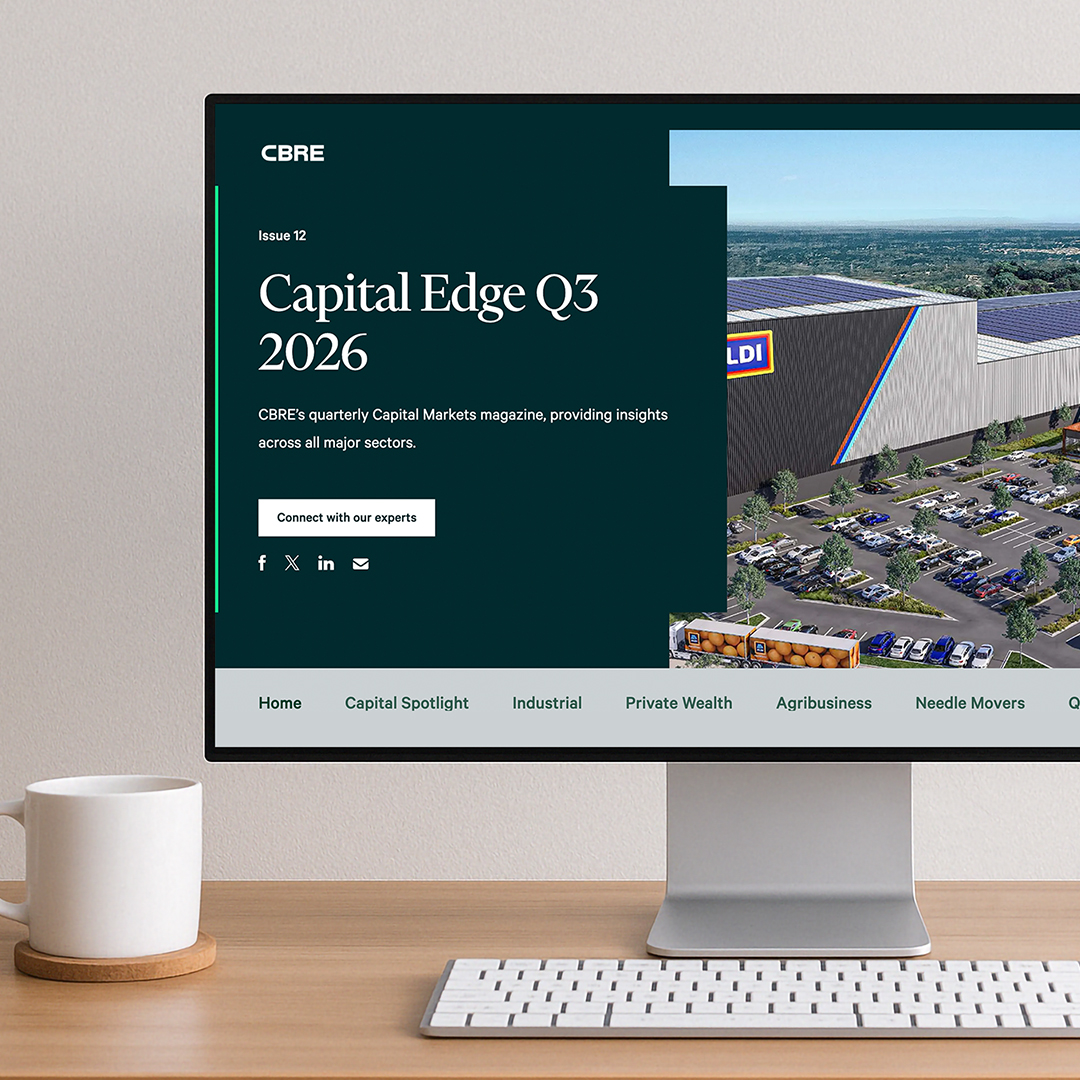 Desktop monitor displaying the CBRE Capital Edge Q3 2026 website on a clean workspace with a keyboard and coffee mug.
