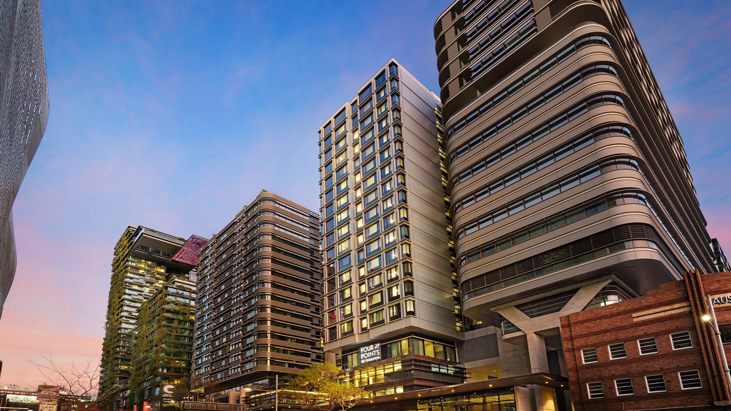 Modern mixed-use high-rise development featuring hotel accommodation within a vibrant urban precinct.