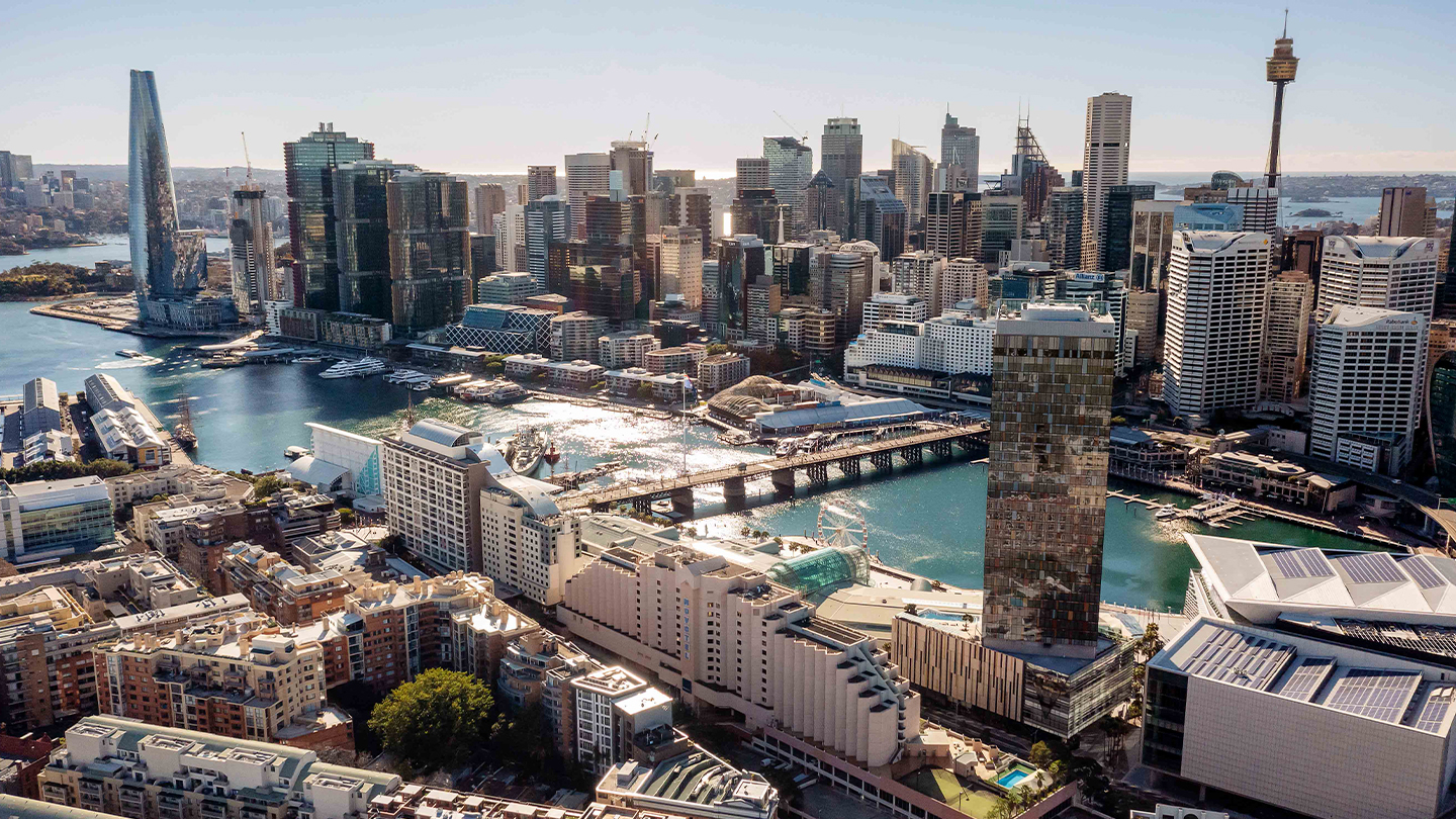 Panoramic view of a major harbour city skyline showcasing a dense mix of commercial, residential and hospitality developments.