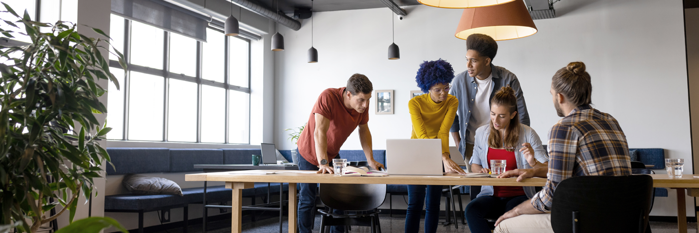 Five people gathered around table working