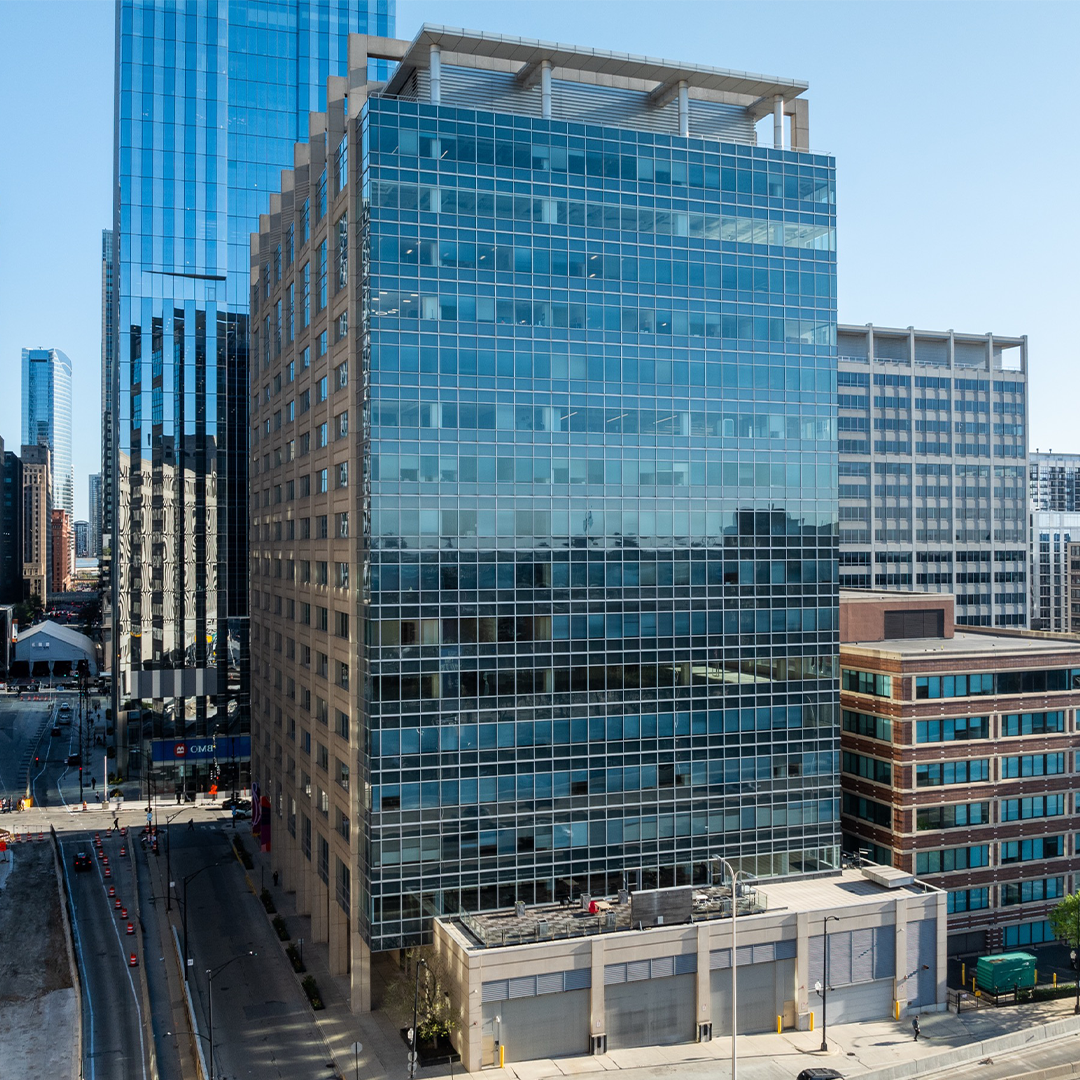 Exterior of a modern glass-curtain-wall office tower in downtown Chicago