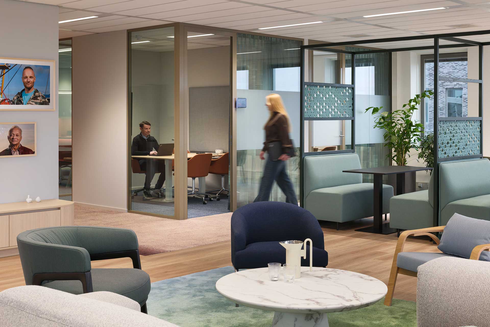 Modern office environment with glass meeting rooms, lounge seating, designer furniture and plenty of natural light.