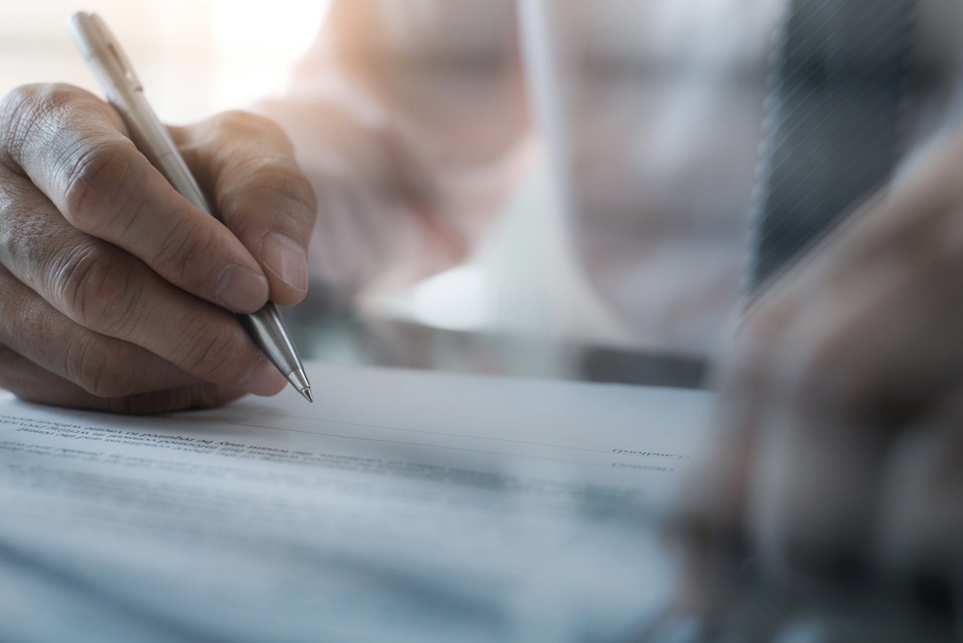 man holding a pen signing a contract