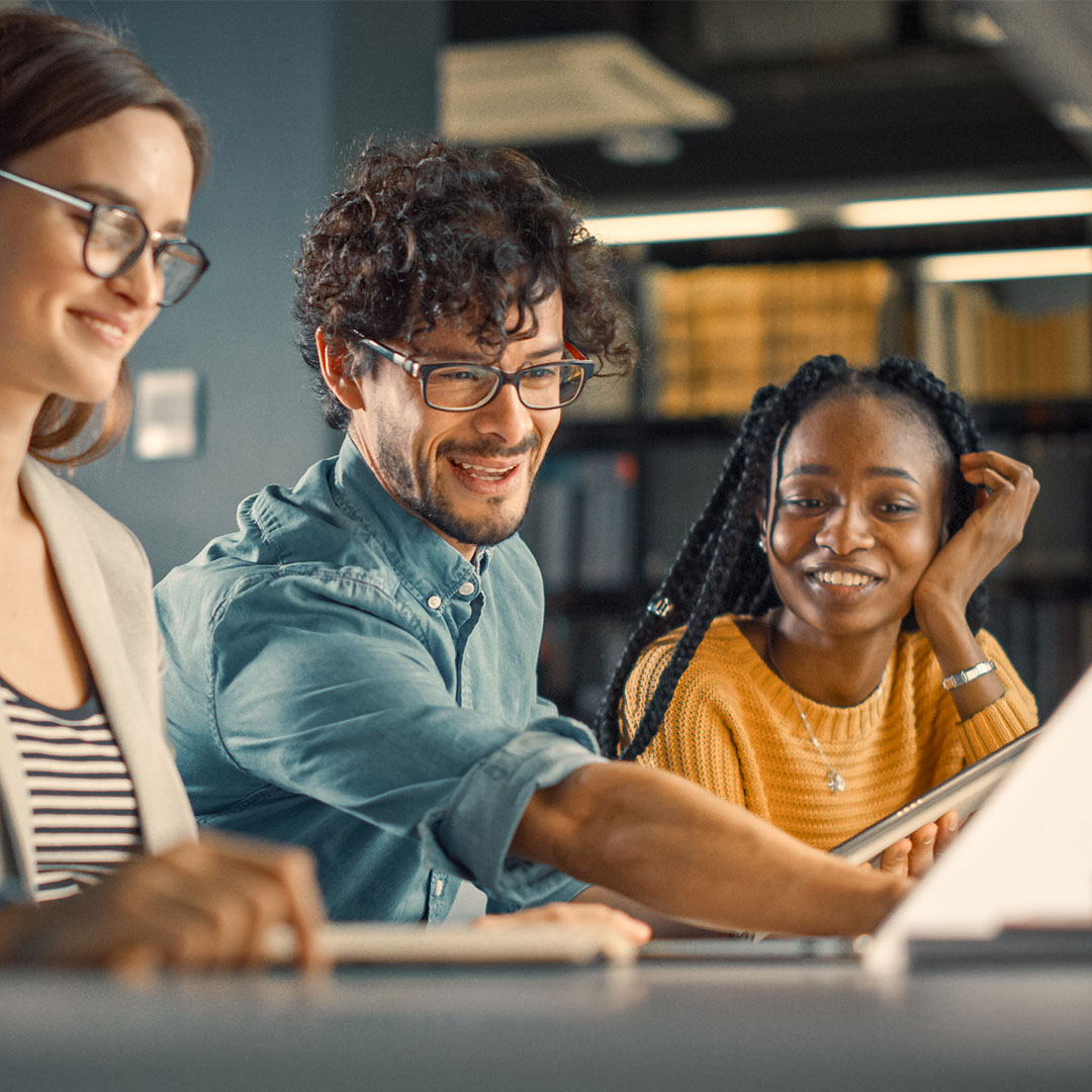 Three people working on a tablet