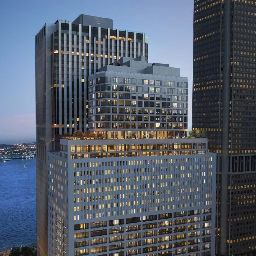 View of a multi‑story office building with illuminated windows at dusk