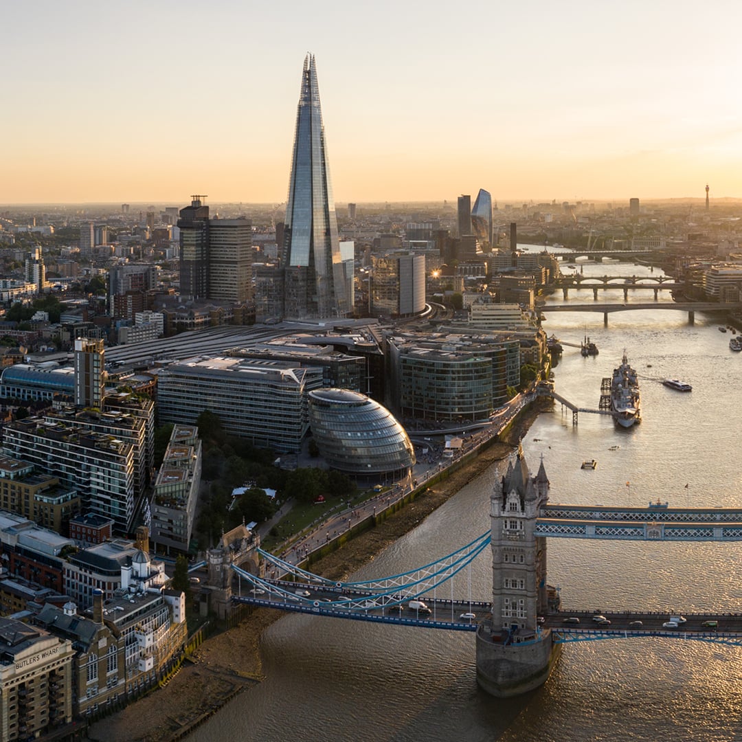 Aerial sunset view of London skyline featuring Tower Bridge over the River Thames