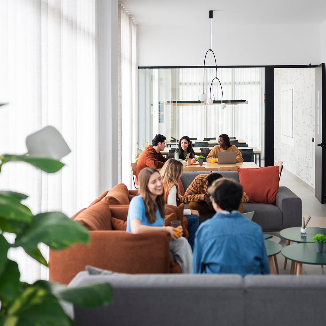 Group collaborating in a modern office lounge with sofas and a central table