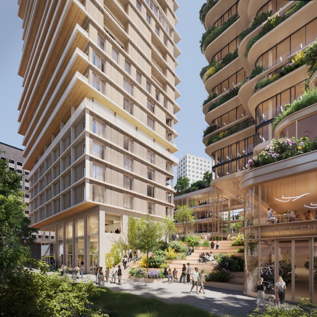 Gebouwencomplex met meerdere niveaus en secties. De architectuur omvat een mix van rechte en gebogen lijnen, met een opvallende gebogen glazen gevel aan één uiteinde. Het gebouw wordt omringd door groen, wegen en geparkeerde auto’s, wat aangeeft dat het zich in een stedelijk gebied bevindt.