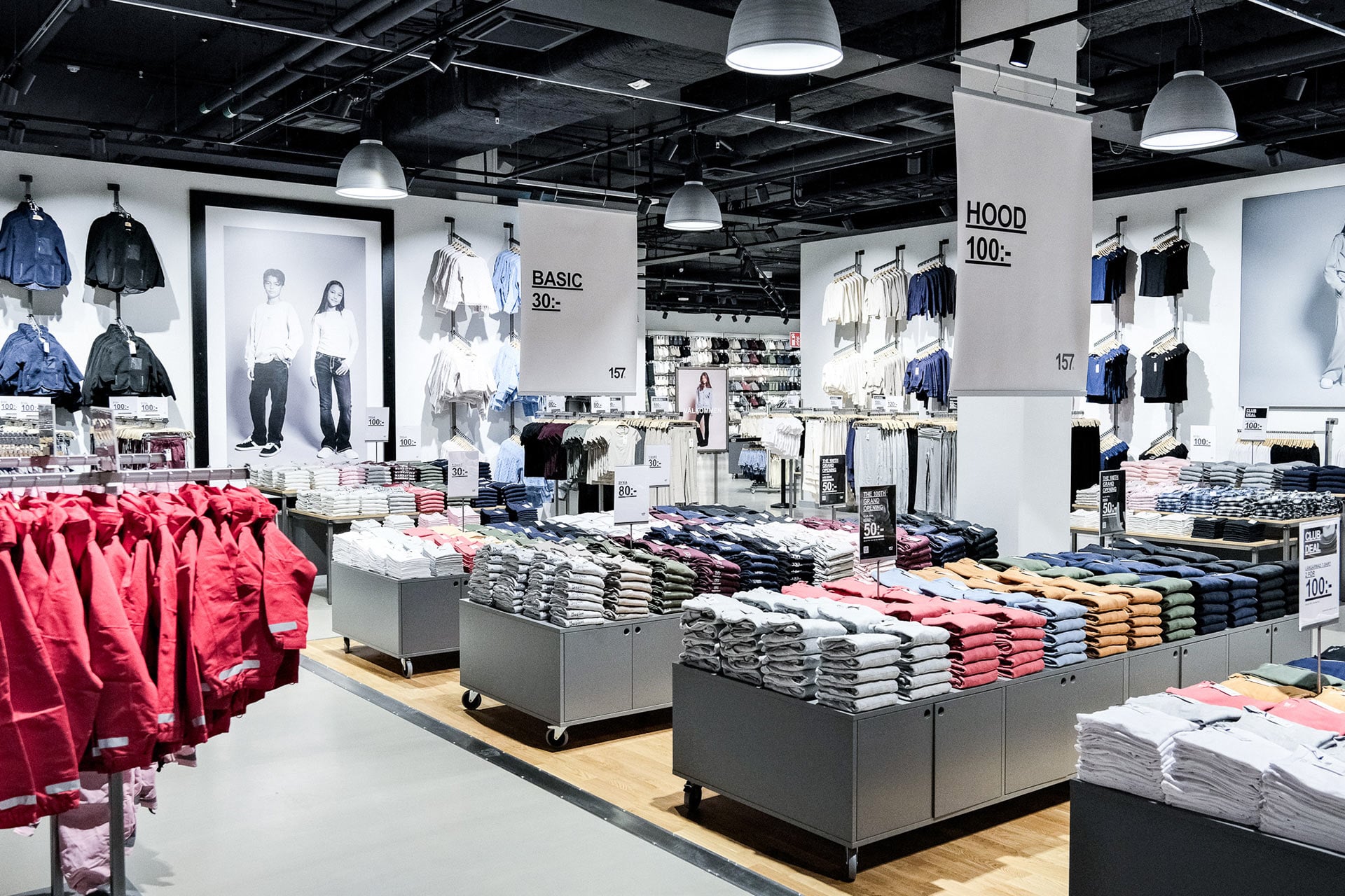 Interior of a modern clothing shop with assorted basics, jumpers and coats.
