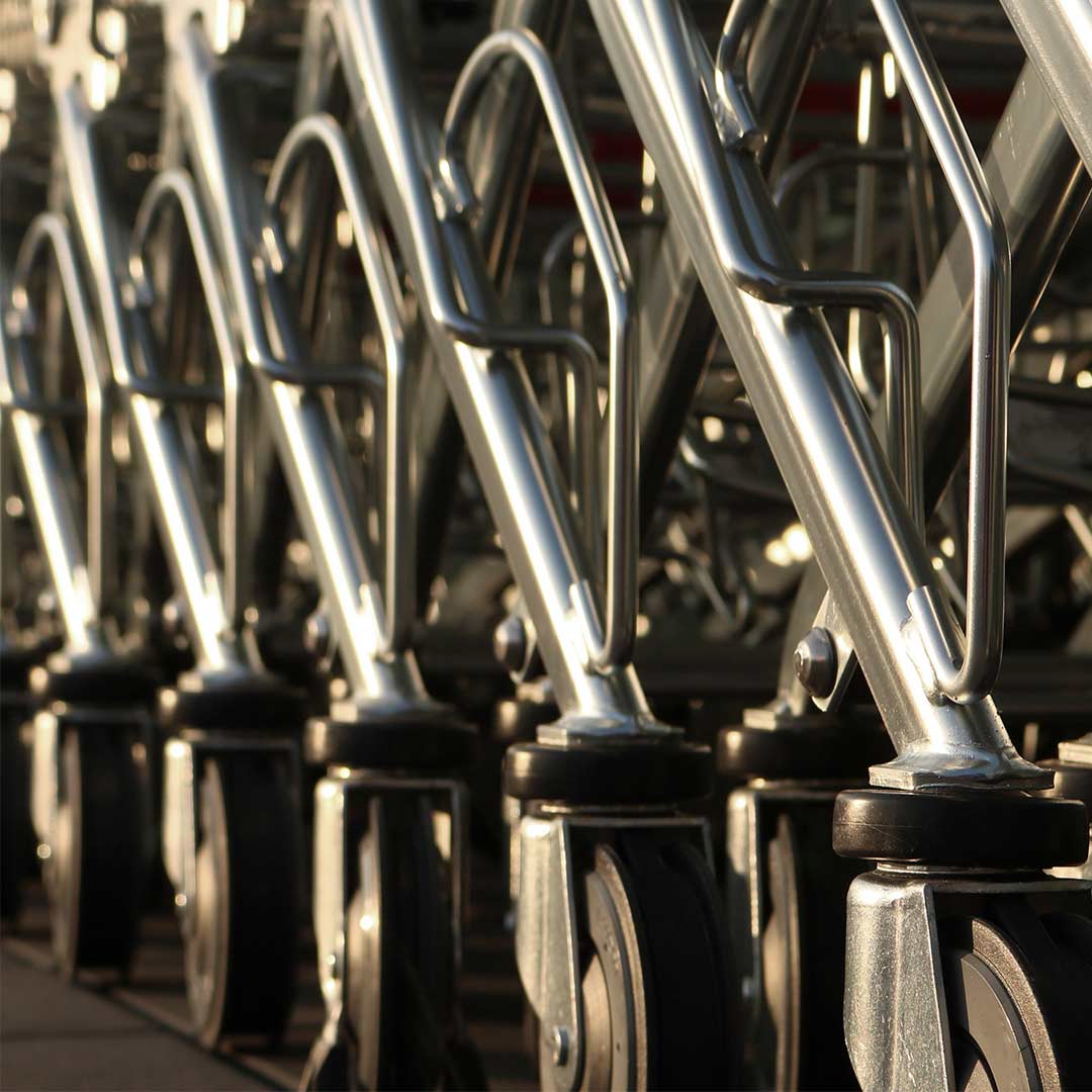 Een groep zilveren frames van winkelwagens, strak en modern van ontwerp, opgesteld in een rij.
