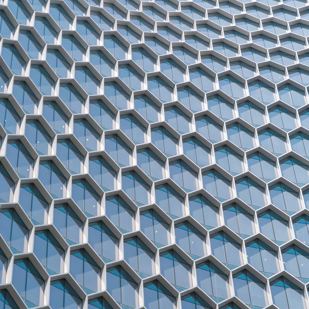 Close-up of a modern office building facade featuring a repeating honeycomb pattern